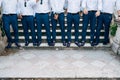 Seven groom& x27;s best men in identical blue trousers and shoes stand on the stairs, close-up