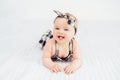 Cute smiling little baby girl sitting on bed. Seven month old infant child on grey soft blanket Royalty Free Stock Photo