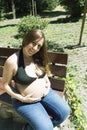 Seven month pregnant woman in a park