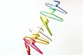 Seven multicolored clothes hangers hangs over the chain