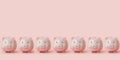 Seven pink ceramic piggy banks stand in row Royalty Free Stock Photo