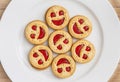 Seven round biscuits smiling faces on the white plate