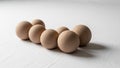 Seven spherical objects resembling eggs are arranged on a white Royalty Free Stock Photo