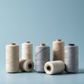 Seven spools of thread are neatly arranged on a light blue surface. The threads are in Royalty Free Stock Photo