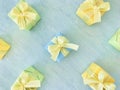 Seven square gift boxes in blue, green ,and yellow colors, arranged neatly, on cyan watercolor texture background. Royalty Free Stock Photo