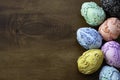 Seven vintage embossed carved vintage Easter eggs on a dark wooden background.