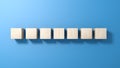 Seven wooden cubes isolated on blue background.