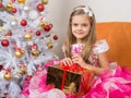 Seven-year girl in beautiful dress sits with a gift in their hands Royalty Free Stock Photo