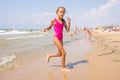 Seven-year girl runs on beach from the sea Royalty Free Stock Photo