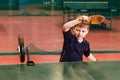 A seven-year-old boy fulfills the roll on the right in table tennis with the help of a robot on the table