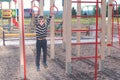 Seven-year-old boy hangs on the gymnastic rings on the Playground.