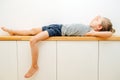 Seven year old boy lying on a corridor shelf, his school closed down