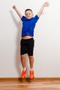 Seven-year-old boy in T-shirt and shorts jumps in sneakers Royalty Free Stock Photo