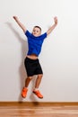 Seven-year-old short-haired boy jumps in sneakers against a white background. Children and sport Royalty Free Stock Photo