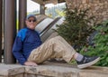 Seventy-four-year-old Caucasian male relaxing on top of a stone wall in Beaver Creek, Colorado. Royalty Free Stock Photo