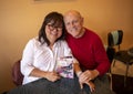 Seventy-three year old Caucasian man in affectionate pose with his sixty-three year-old Korean wife on Mother`s Day.