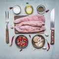 Several appetizing turkey steaks on a cutting board with a variety spices and oil rustic wooden background top view