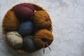 Several balls of colorful knitting yarns lie in a wicker basket on a marble background. Royalty Free Stock Photo