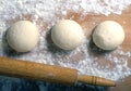Several balls of dough and rolling pin