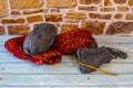 Several balls of yarn and a crochet hook with a wool hand warmer started