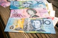 Several banknotes of Australian dollars on the aged wooden surface, close up.