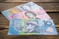 Several banknotes of Australian dollars on the aged wooden surface, close up.