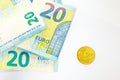 Several banknotes of 20 euros and a coin of 20 cents. The concept of opposing large and small earnings, saving or spending money