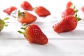 Several berries of red ripe strawberries on the white wooden surface