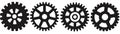 Several black gears casting shadows on a white backdrop Royalty Free Stock Photo