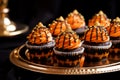 Several black and orange Halloween cupcakes on a golden plate