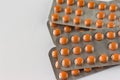 Several blisters with medicine pills on neutral white background. Pile of tablets, capsules