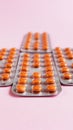 Several blisters with medicine pills on pink background. Rows of tablets, capsules