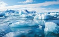 Several blue icebergs in blue ocean water against the sky