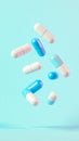 Blue and white medicine capsules falling on light blue background Royalty Free Stock Photo