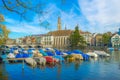 several boats are anchoring on the limmat river in zurich with famous Grossmunster cathedral behind them...IMAGE