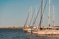 Several boats with masts are docked in the port, on a hot summer evening. Royalty Free Stock Photo