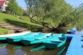 several boats moored to a small bridge by the river