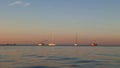 Several boats on the sea horizon at sunset. Warm summer evening.