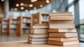 Several books are on a table, one is open, with shelves full of books in the background during the day Royalty Free Stock Photo