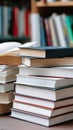 Several books are on a table, one is open, with shelves full of books in the background during the day Royalty Free Stock Photo