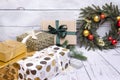 several boxes in a gift box, Christmas wreath with red and Golden Christmas balls, snowflake, cinnamon sticks on a wooden