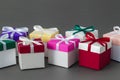 Several bright colorful gift boxes with ribbons on gray background.