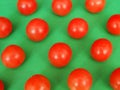 Several bright red cherry tomatoes ordered by green background Royalty Free Stock Photo