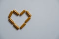 Several brown capsules, arranged in a heart shape Royalty Free Stock Photo