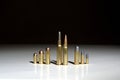 Several bullets of different calibers standing on a white surface with a black background