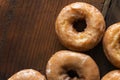 Several cake doughnuts glazed with icing on a stained wood background. Royalty Free Stock Photo