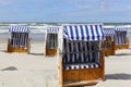 Several canopied beach chairs by a sea coast