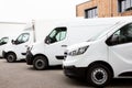 Several cars vans trucks parked in parking lot for rent delivery white vans in service van truck front of entrance of warehouse