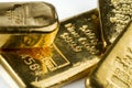 Several cast gold bars of different weights on white background. Royalty Free Stock Photo
