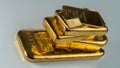 Several cast and minted gold bars on a gray background. Royalty Free Stock Photo